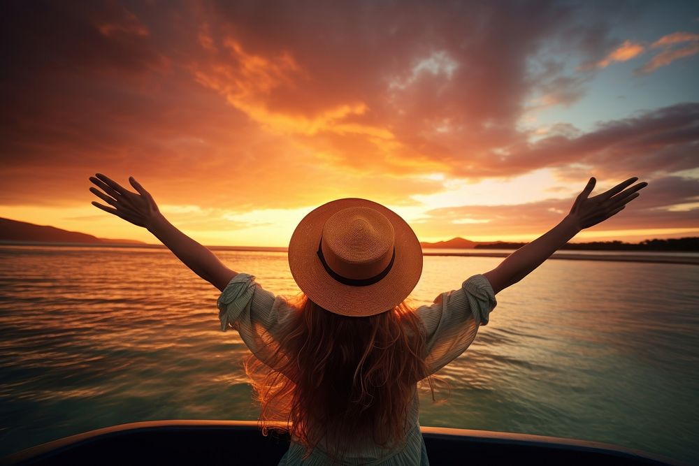 Happy girl wearing a hat with arms up enjoy freedom at the beach at sunset outdoors nature adult. AI generated Image by…