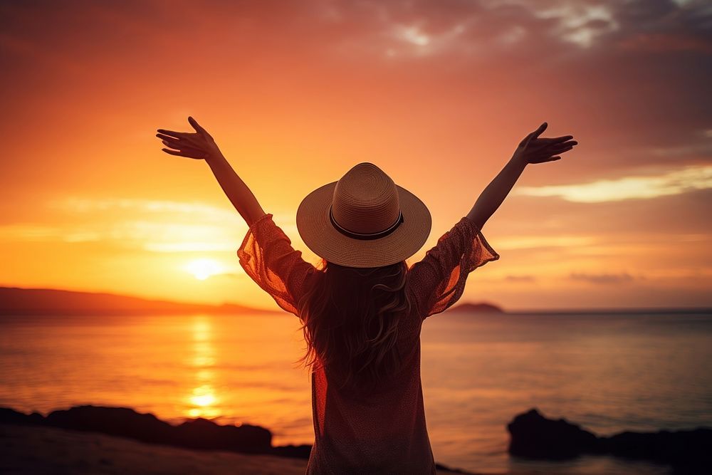 Happy girl wearing a hat with arms up enjoy freedom at the beach at sunset adult happy tranquility. AI generated Image by…