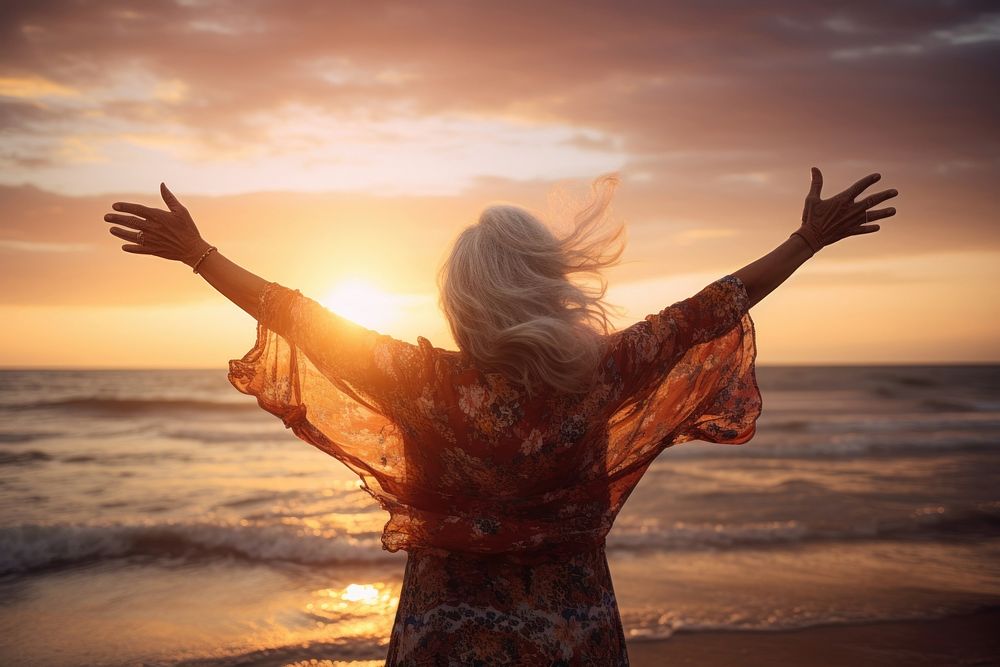 Happy grandma with arms up enjoy freedom at the beach at sunset outdoors nature adult. AI generated Image by rawpixel.