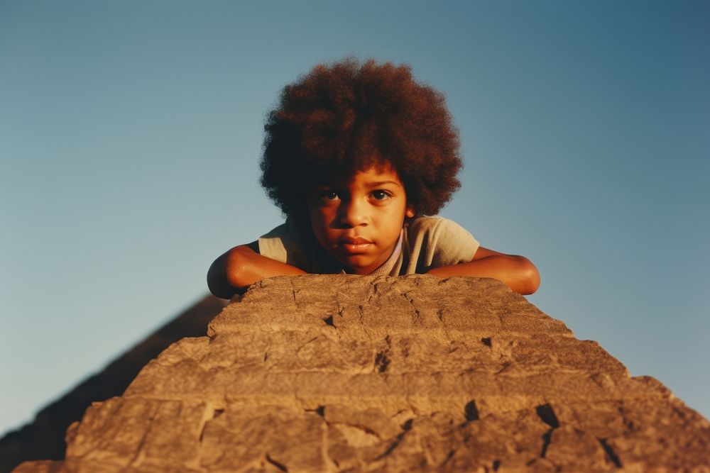 A little black kid on top of the pyramid photography portrait outdoors. AI generated Image by rawpixel.