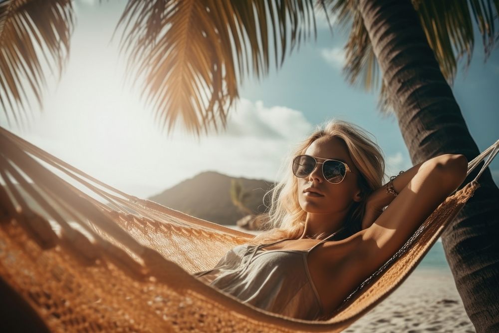 A blonde hair woman sleeping in a hammock under the coconut tree on the beach vacation glasses adult. AI generated Image by…