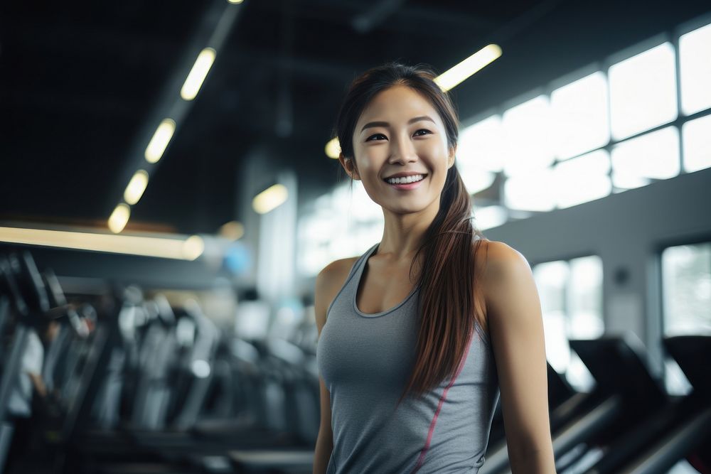 Asian woman in sportswear walking in a gym smiling fitness smile. AI generated Image by rawpixel.
