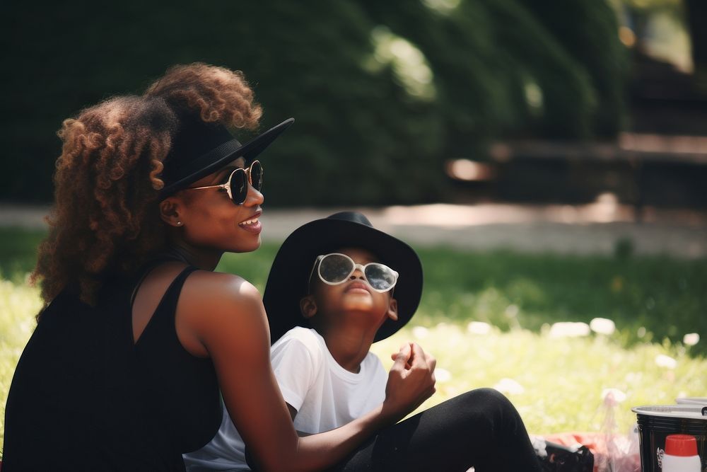 Black mother and child sit picnic in a park photography sunglasses portrait. AI generated Image by rawpixel.