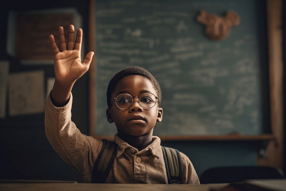 An african american boy raises his hand in his class blackboard classroom portrait. AI generated Image by rawpixel.