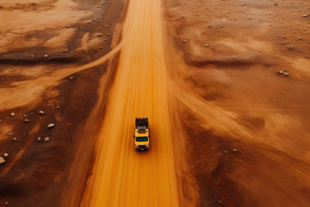 An orange road and yellow mining trucks outdoors vehicle desert. AI generated Image by rawpixel.