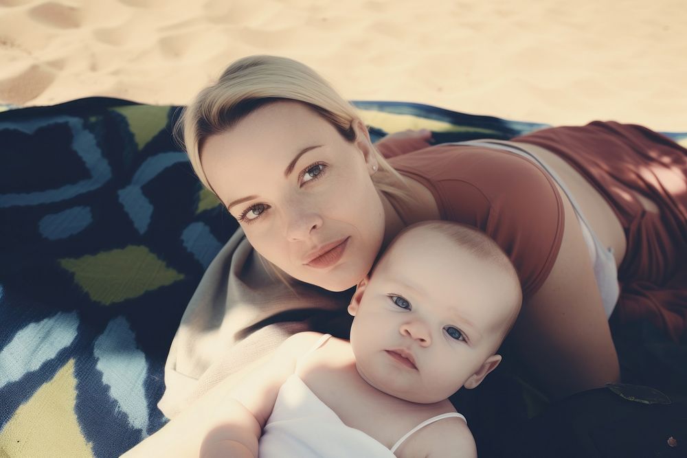 Mom on a beach mat with a baby in tow photography portrait family. AI generated Image by rawpixel.