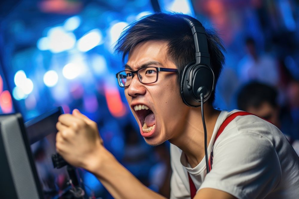 Asian male wearing headphone gaming and eyeglasses in game tournament headphones shouting headset. 