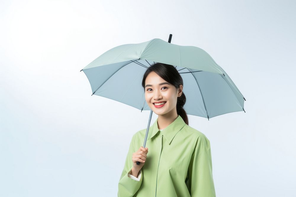 Happy smile asian woman wearing a light green patient outfit with an blue umbrella adult coat white background. AI generated…