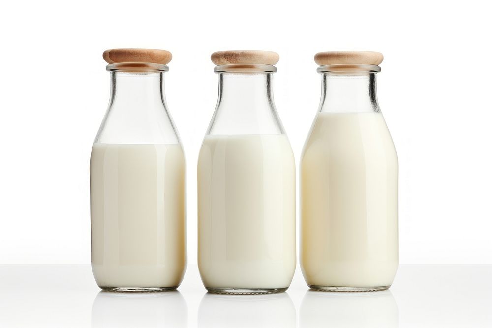Three milk bottles of varying heights dairy drink white background. AI generated Image by rawpixel.