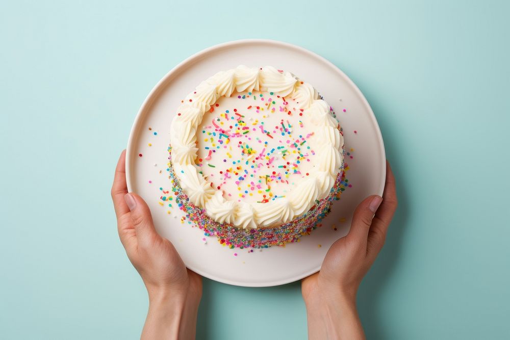 Hands holding birthday cake on plate sprinkles dessert cupcake. AI generated Image by rawpixel.