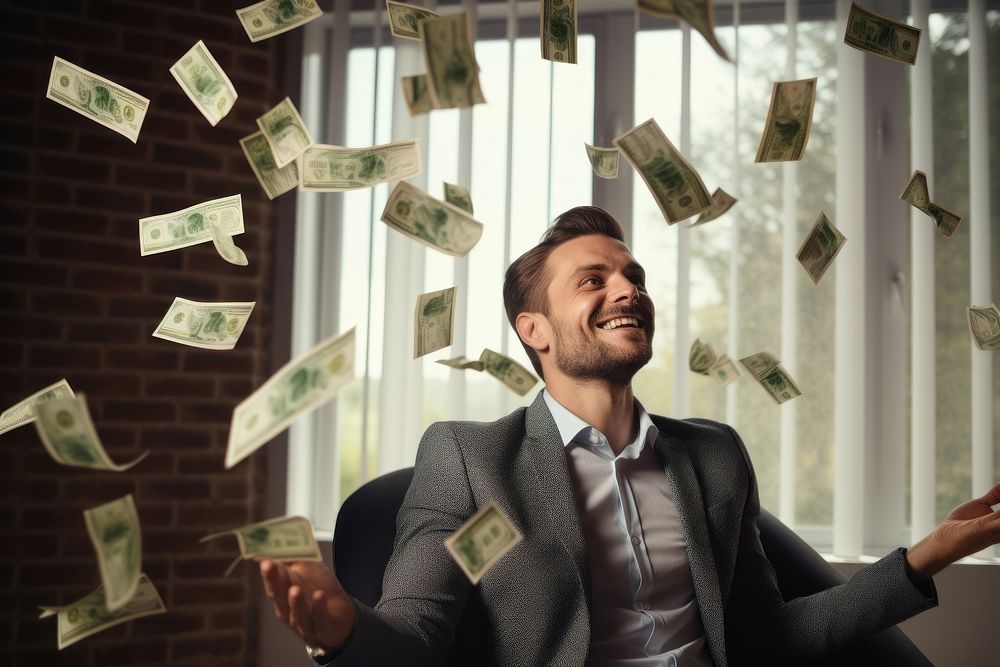 Happy man with cash dollars flying in home office money adult happy. AI generated Image by rawpixel.