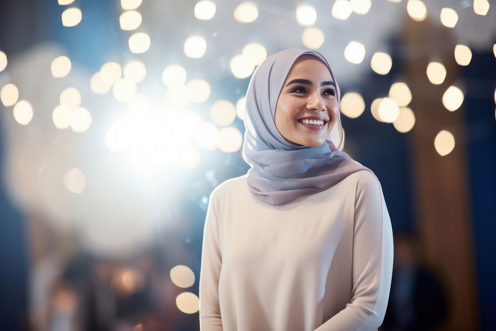 A muslim woman standing of stage going to give a presentation to audience smile scarf happy. AI generated Image by rawpixel.