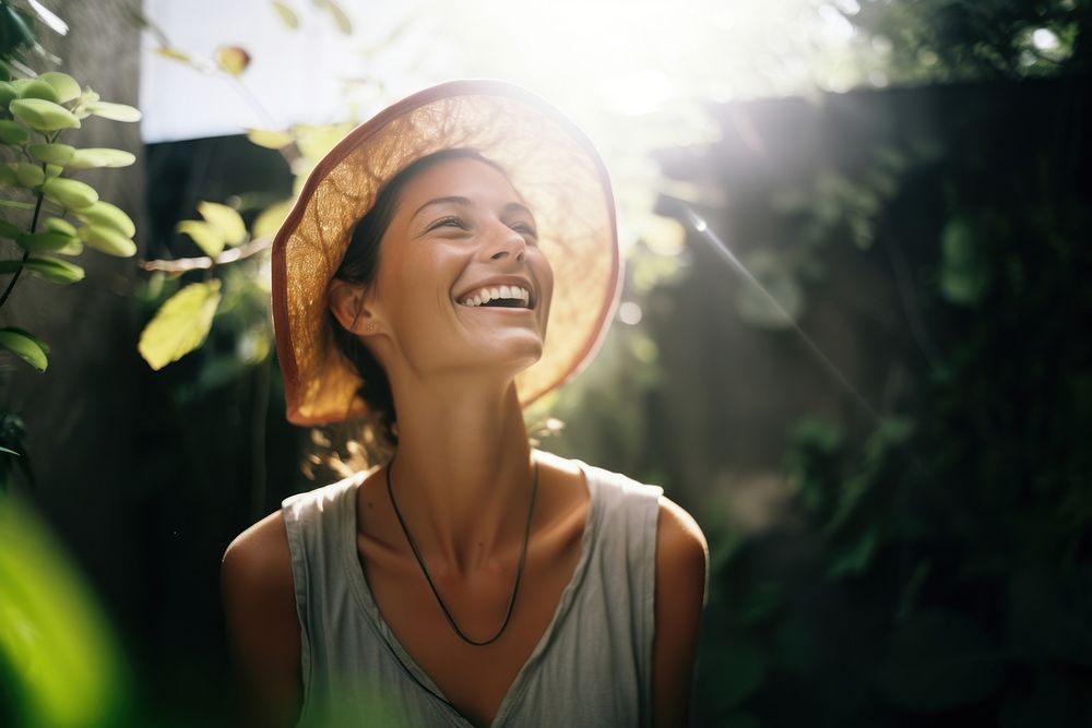 A woman smile to the sun light laughing adult hat. AI generated Image by rawpixel.
