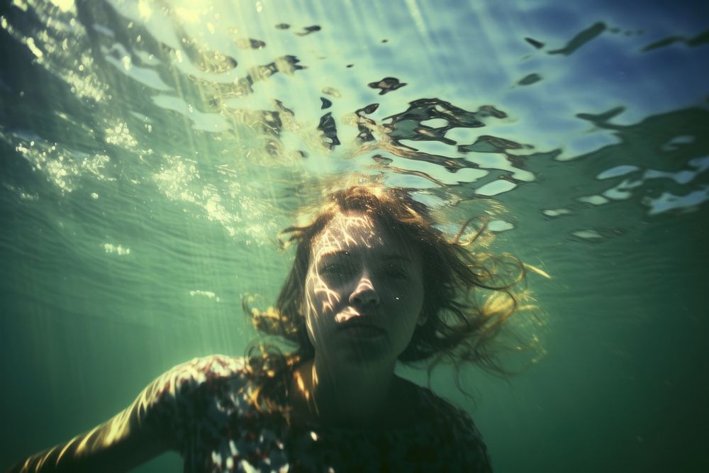 A woman swimming in the sea photography underwater portrait. AI generated Image by rawpixel.