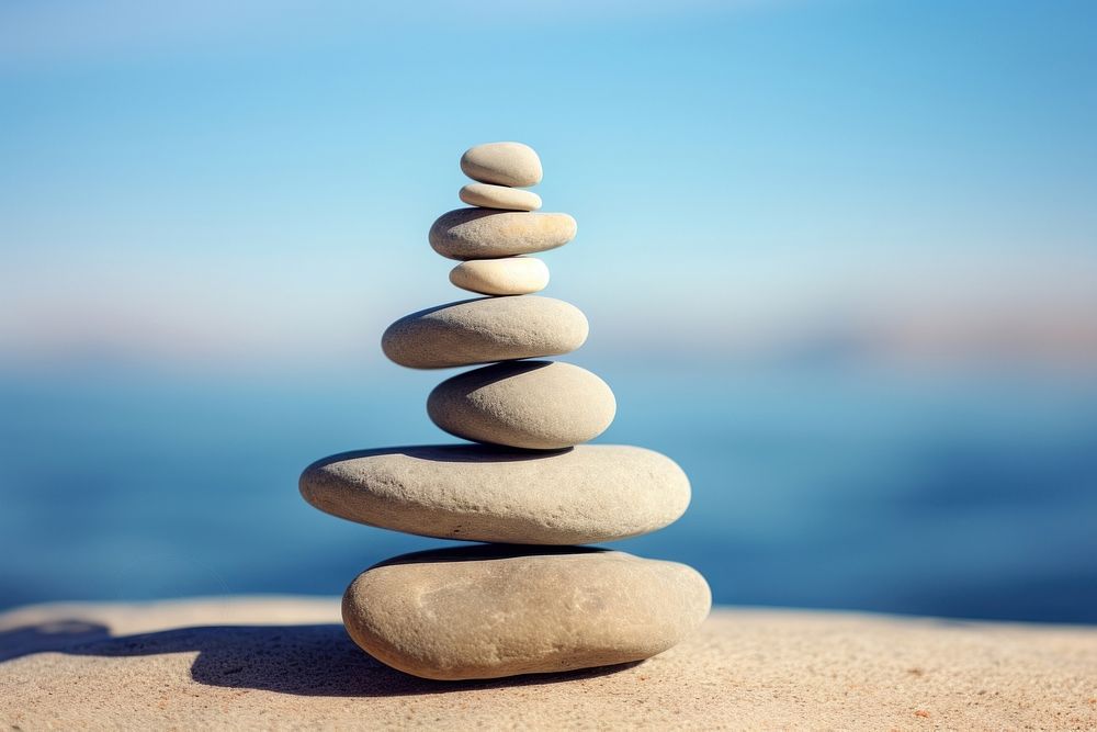 A Six rocks are stacked on top of each other pebble blue sky. AI generated Image by rawpixel.