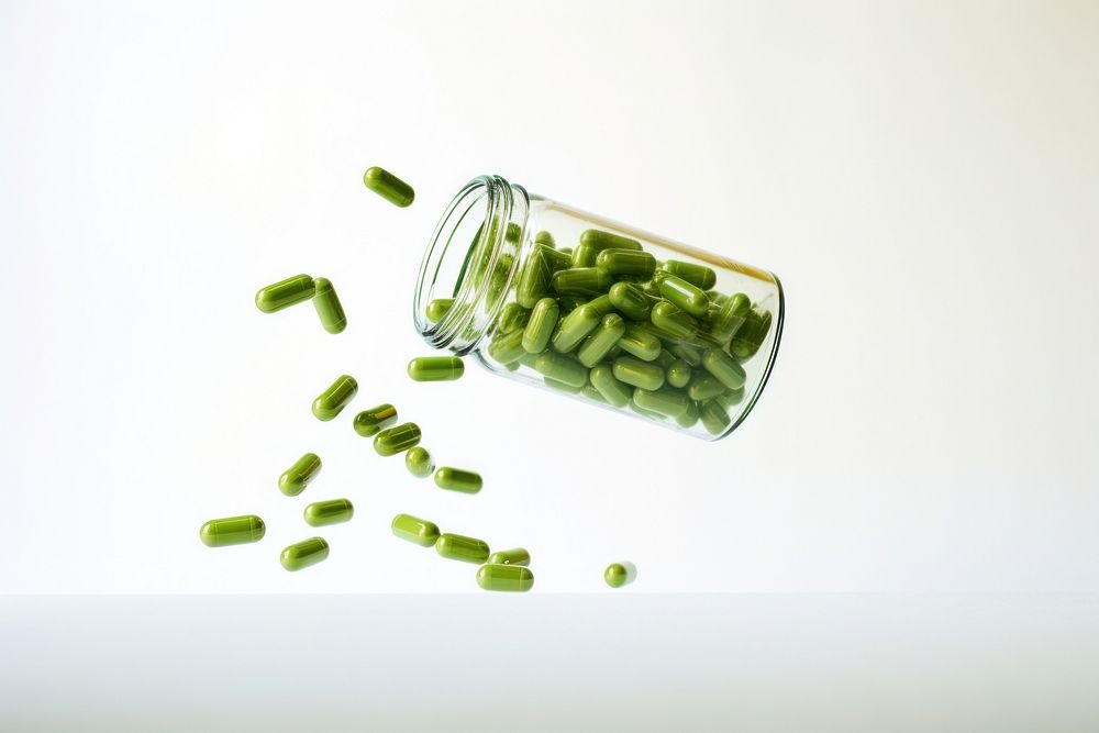 Herbal capsules spilling out of bottle white background medication container. AI generated Image by rawpixel.