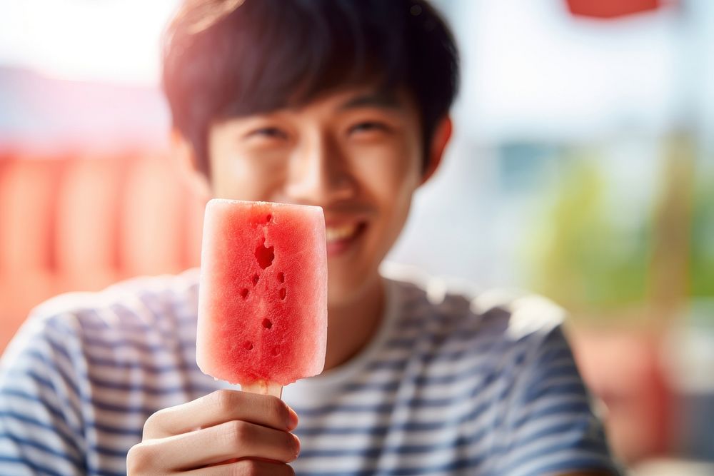 Young man eating strawberry ice lolly food face refreshment. AI generated Image by rawpixel.