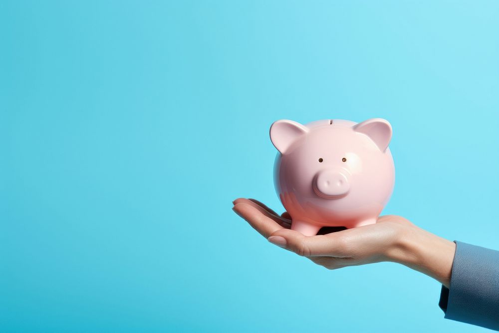 Hand holding piggy bank blue blue background representation. AI generated Image by rawpixel.