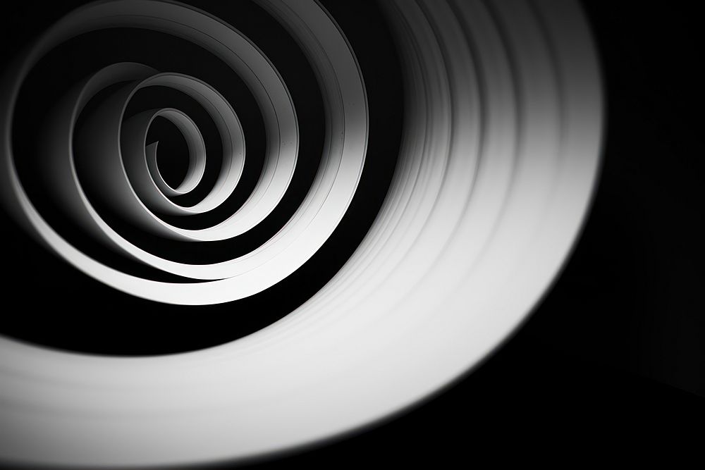 A black and white photo of a circular object spiral backgrounds electronics. AI generated Image by rawpixel.