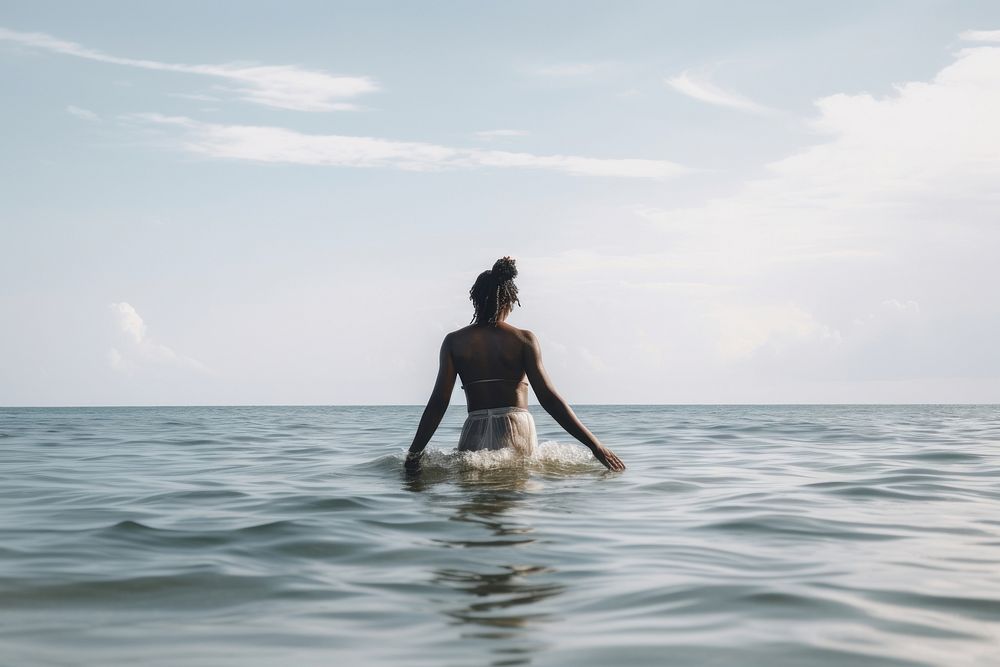 Young black woman wading into ocean swimming outdoors horizon. AI generated Image by rawpixel.