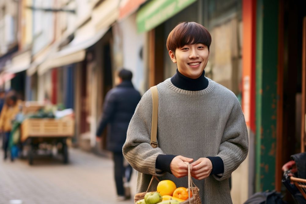 Young handsome Korean man enjoying local street food sweater smile adult. AI generated Image by rawpixel.