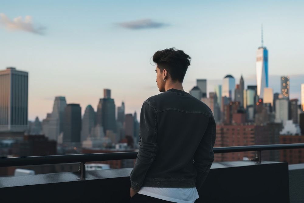 Young man looking out at Manhattan skyline architecture photography cityscape. AI generated Image by rawpixel.
