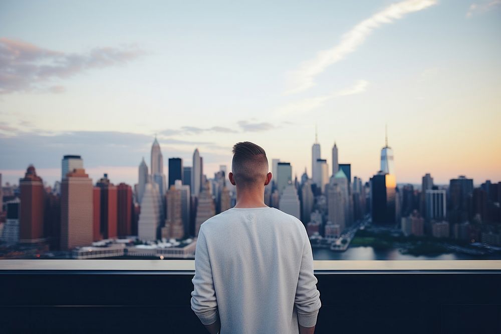 Young man looking out at Manhattan skyline architecture photography landscape. AI generated Image by rawpixel.