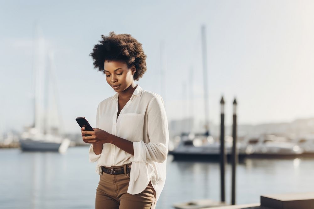 Black woman with cell phone standing at the waterfront travel adult transportation. AI generated Image by rawpixel.