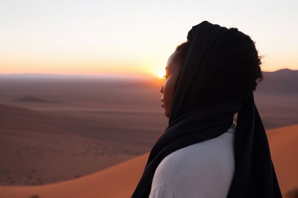 Black young woman watching sunset at desert outdoors horizon nature. 