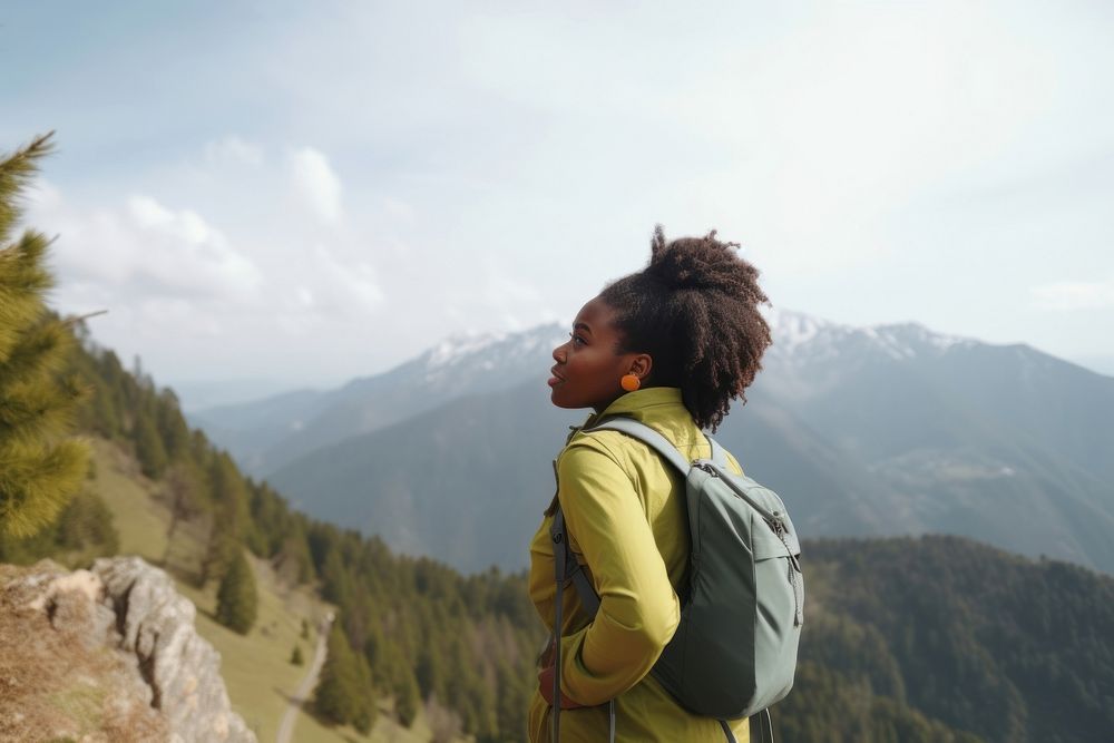Black young woman enjoying view from outlook during hike in mountains backpacking recreation adventure. AI generated Image…