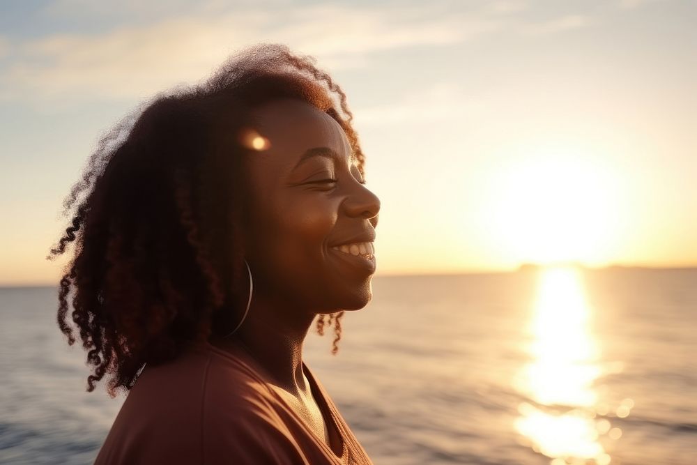 Black mature woman enjoying sunset by the sea outdoors nature travel. AI generated Image by rawpixel.