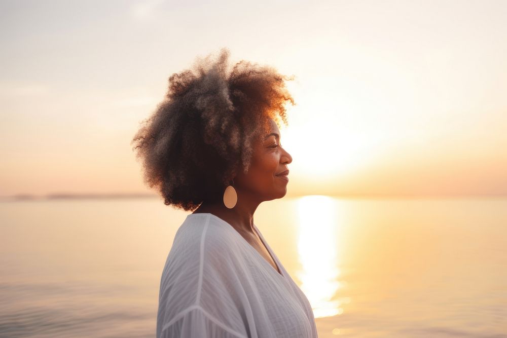 Black mature woman enjoying sunset by the sea portrait outdoors nature. AI generated Image by rawpixel.