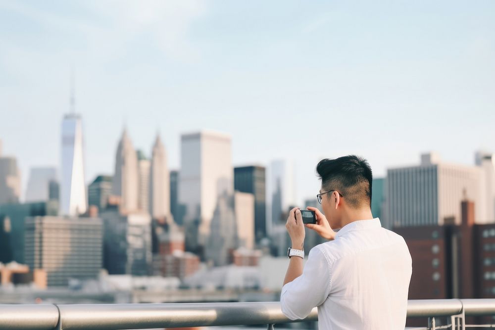 Chinese man using smartphone with headphones on rooftop adult photo architecture. 