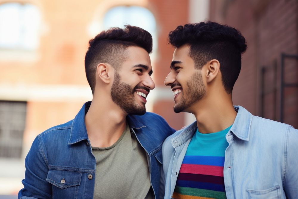 Hispanic Two happy smiling friends from lgbt community standing looking at each other together laughing smile adult. AI…