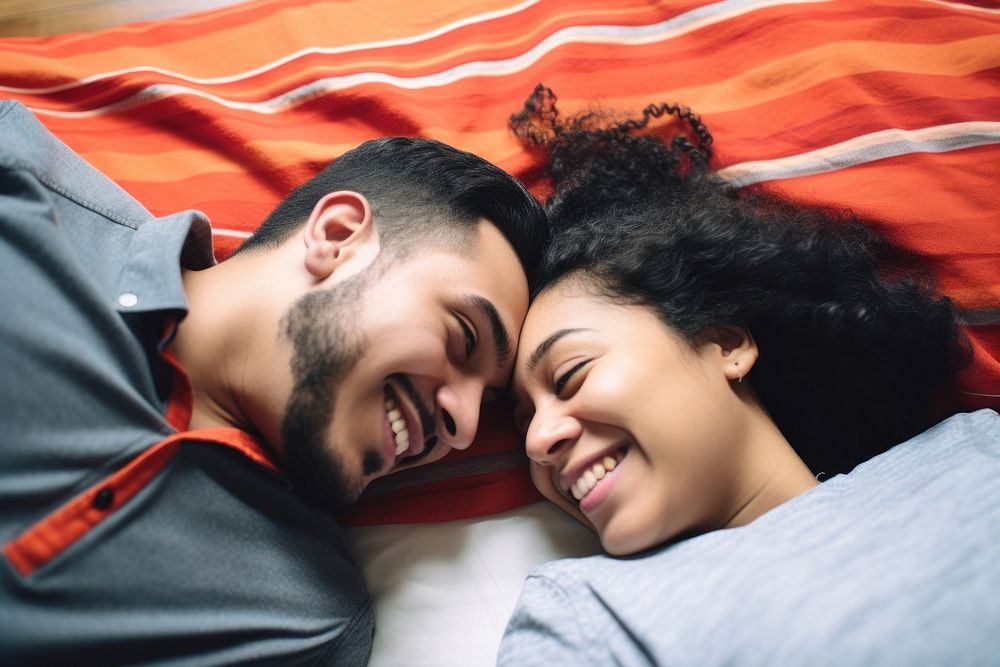 Hispanic Young couple lying on bed together adult affectionate togetherness. AI generated Image by rawpixel.