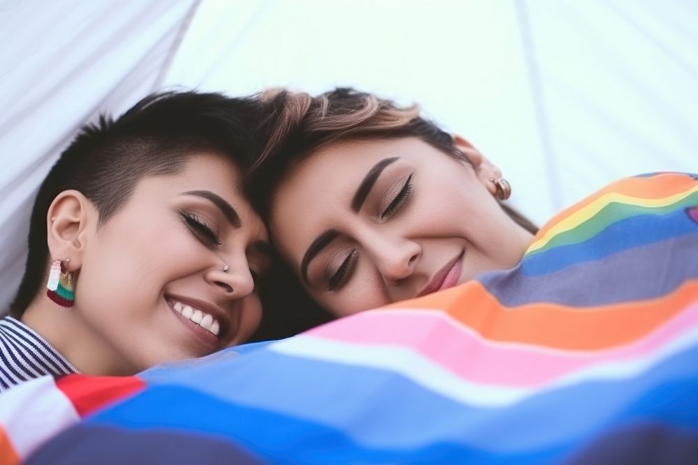 Hispanic Happy loving lesbian LGBT couple lie on the bedspread in the park blanket adult happy. AI generated Image by…
