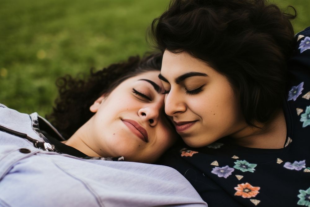 Hispanic Happy loving lesbian LGBT couple lie on the bedspread in the park photography portrait hugging. AI generated Image…