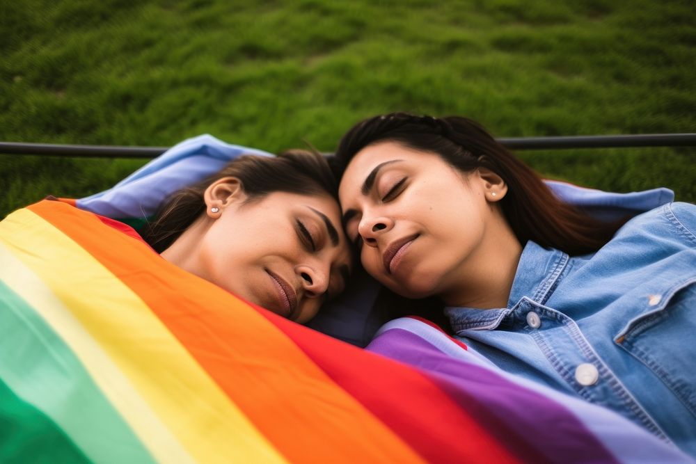 Latinx Happy loving lesbian LGBT couple lie on the bedspread in the park blanket adult plant. AI generated Image by rawpixel.