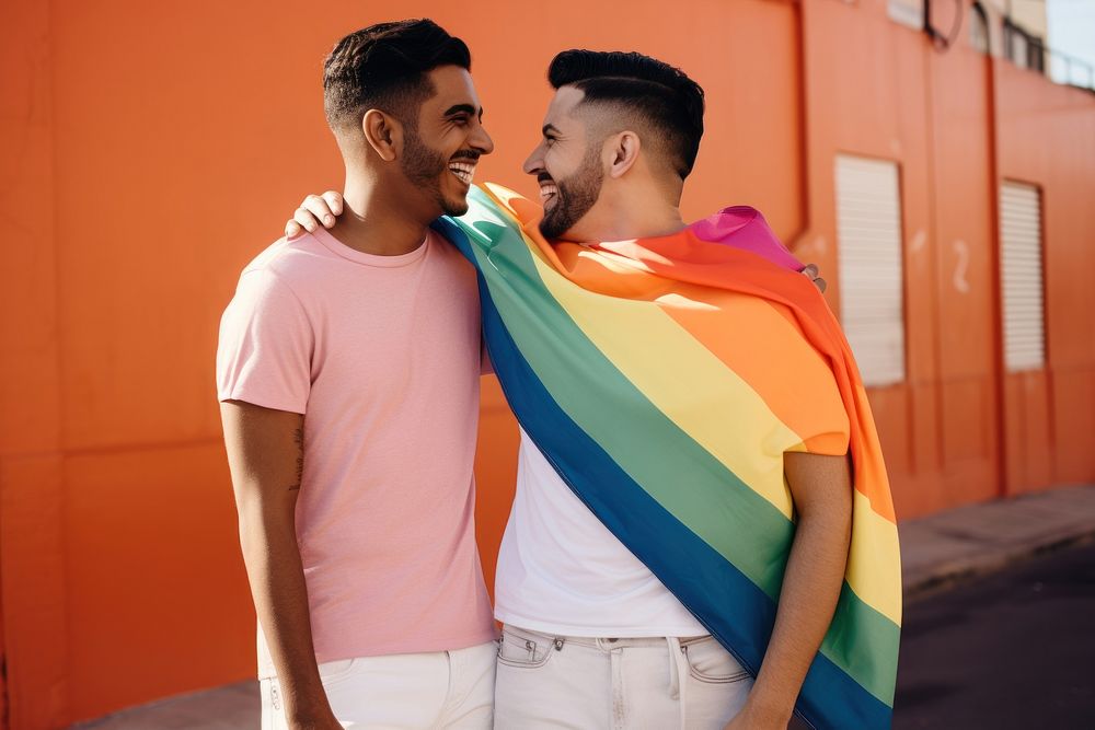 Latinx Two happy smiling friends from lgbt community standing looking at each other together adult togetherness…
