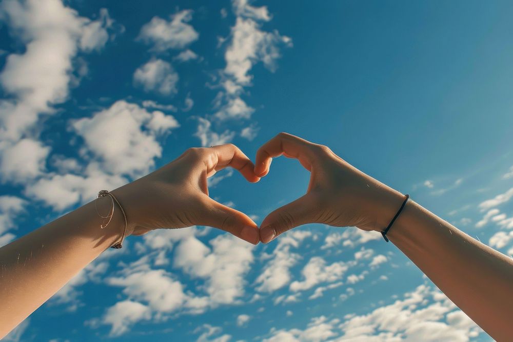 Two hands that are making a heart shape sky togetherness accessories. AI generated Image by rawpixel.