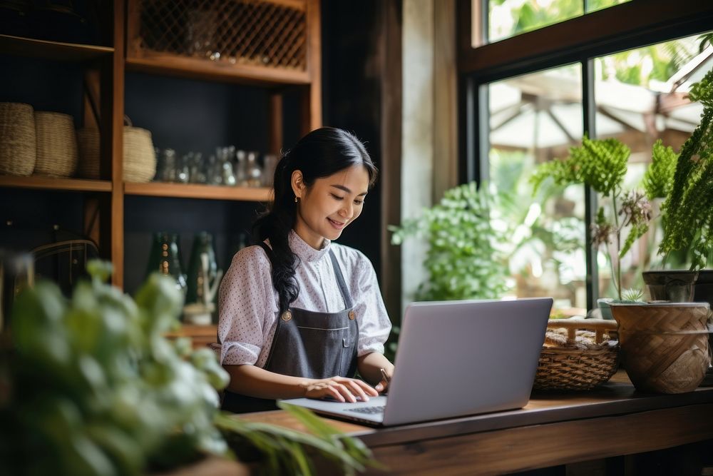 Thai woman working at home computer laptop plant. AI generated Image by rawpixel.