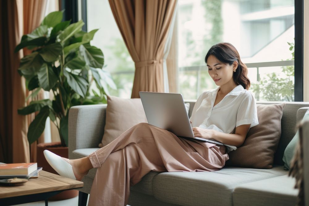 Thai woman working at home sitting computer laptop. AI generated Image by rawpixel.