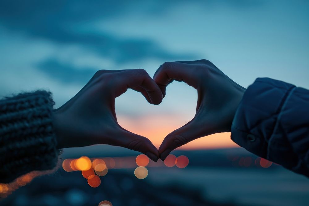 Two hands that are making a heart shape adult blue sky. 