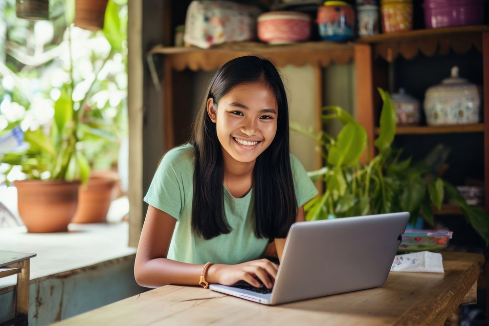 Smiling girl doing work at home laptop computer sitting. AI generated Image by rawpixel.