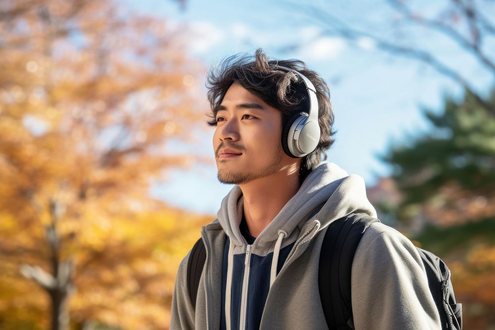Japanese man headphones listening autumn. AI generated Image by rawpixel.