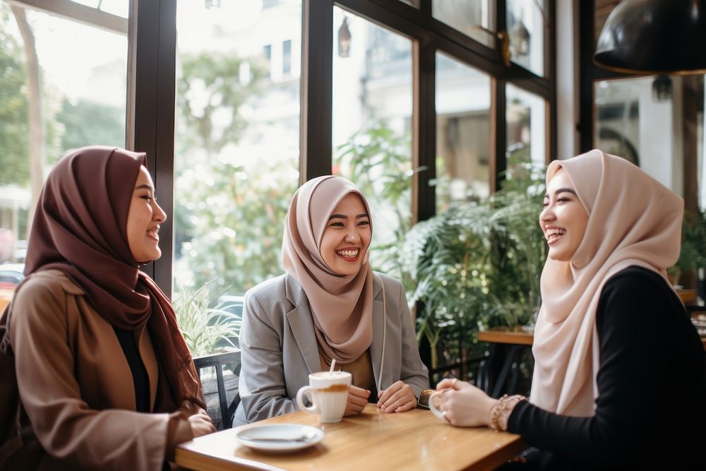 Women in hijab laughing at a coffee shop scarf adult togetherness. AI generated Image by rawpixel.