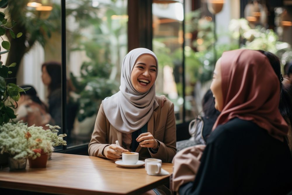 Women in hijab laughing at a coffee shop adult smile togetherness. AI generated Image by rawpixel.