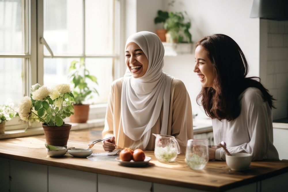 Women in hijab laughing at a kitchen adult togetherness refreshment. AI generated Image by rawpixel.