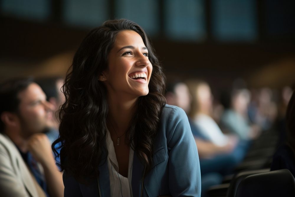 Young Hispanic woman speaker on professional stage in meeting laughing smiling adult. AI generated Image by rawpixel.