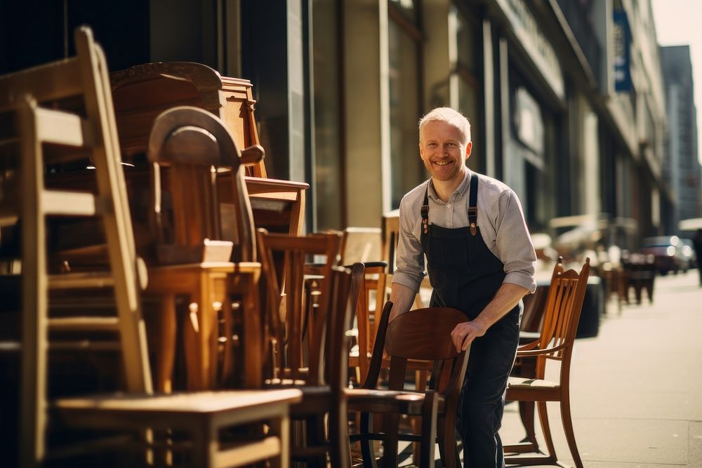 A man in apron holding an old chair furniture adult wood. AI generated Image by rawpixel.
